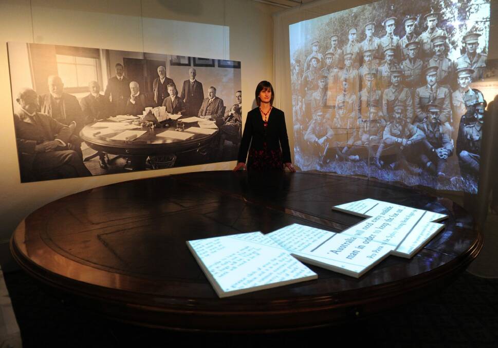 Curator Libby Stewart at the table where the decision was made to commit Australian forces to war on August 3, 1914. Photo: Melissa Adams