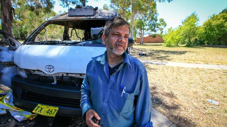 Mohammad Hussain next to his maxi taxi, which was destroyed by vandals. Photo: Katherine Griffiths