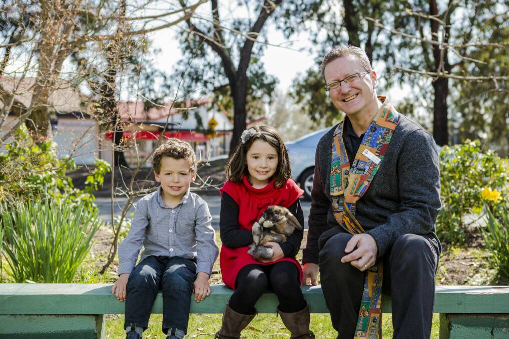 Siblings Cameron Harper 4, and Chloe Harper 7 with their rabbit Bambi, and minister of the Kippax Uniting Church, Gordon Ramsay, at  the animals service. Photo: Jamila Toderas
