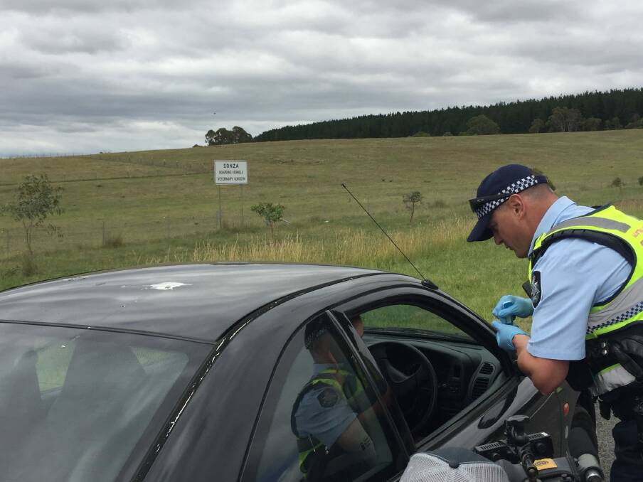An ACT Policing officer performs a drug test on the side of the Kings Highway near Queanbeyan. Photo: Supplied