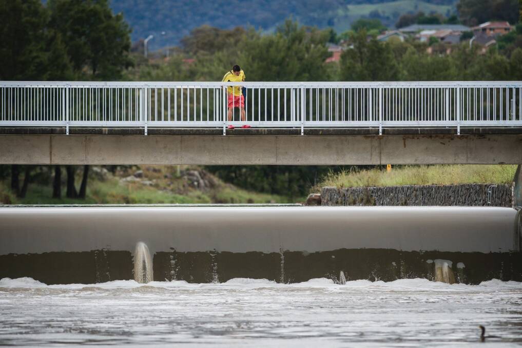 A man examines the water level in Lake Tuggeranong last month.  Photo: Sitthixay Ditthavong