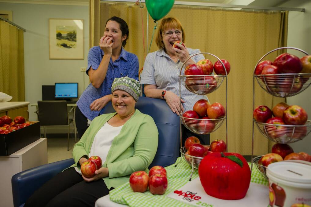 The Oncology unit at National Capital Hospital are ready to 'take the bite out' of their red apples to support Red Apple Day. Behind from left, Nurse Unit Manager for Oncology Kate Stafford, and Nurse Cathie Trotter. Front, National Capital Hospital patient Melissa Veal. Photo: Jamila Toderas