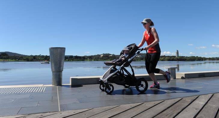 Enjoying the sunshine ... lunchtime jogger Melissa Eagles with her 13 month old son, Finn, hitching a ride. Photo: Graham Tidy