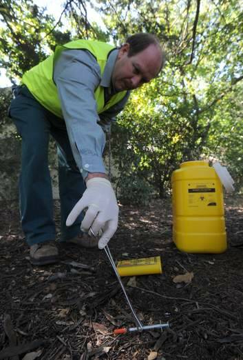 Territory and Municipal Services senior ranger Glenn Tomlinson collects a syringe on his rounds in an inner-north suburb. Photo: Graham Tidy