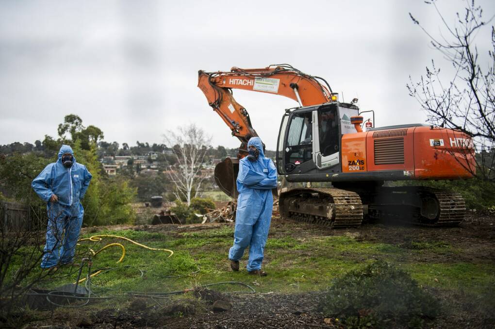 Workers in protective suits demolish a Mr Fluffy home in Farrer last year. Photo: Rohan Thomson