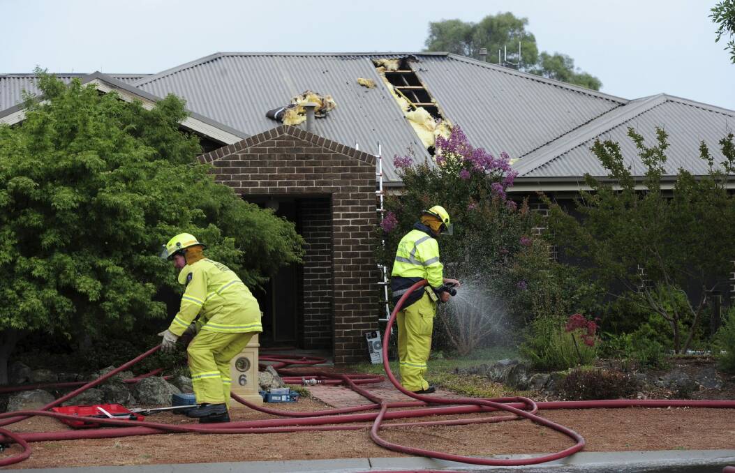 Mopping up: A home in Menzel Crescent, Dunlop, was struck by lightning. Photo: Graham Tidy