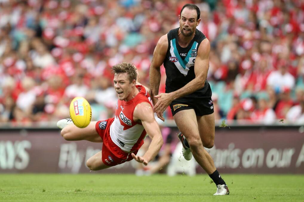 Out-contested: Luke Parker of the Swans falls as he competes for the ball with Matthew Broadbent. Photo: Mark Kolbe