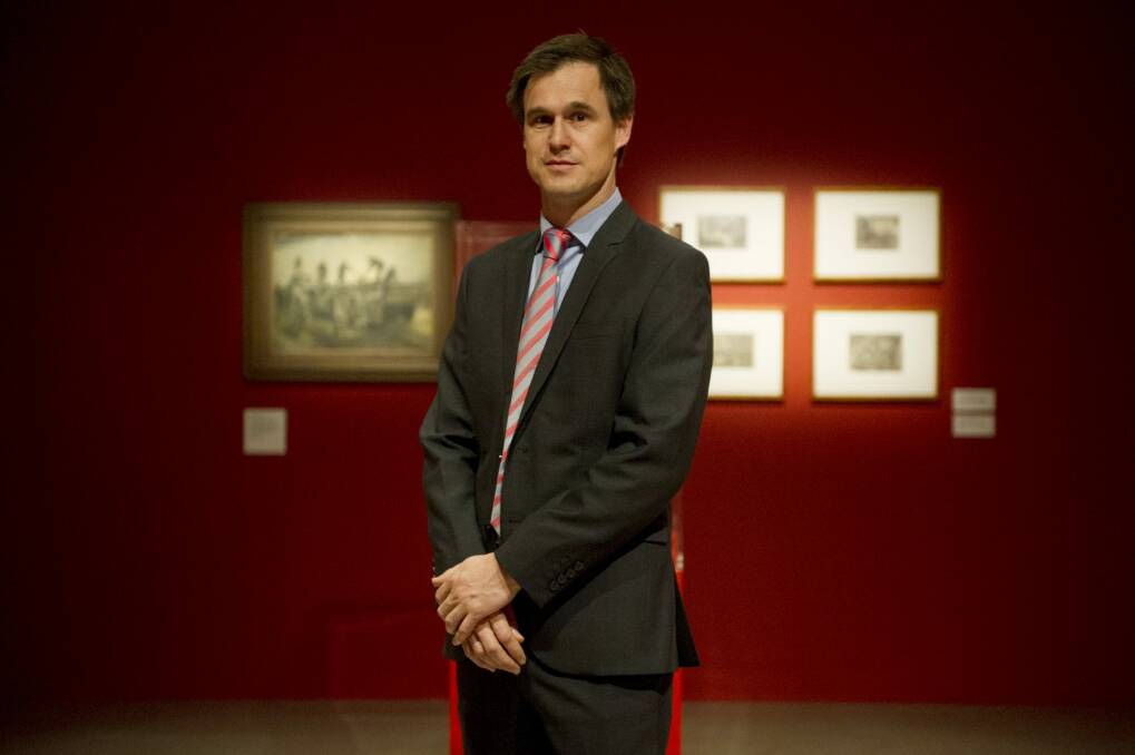 Curator of art at the Australian War Memorial, Warwick Heywood, stands in the special exhibitions gallery where <i>Reality in flames</i> is being shown. Photo: Jay Cronan