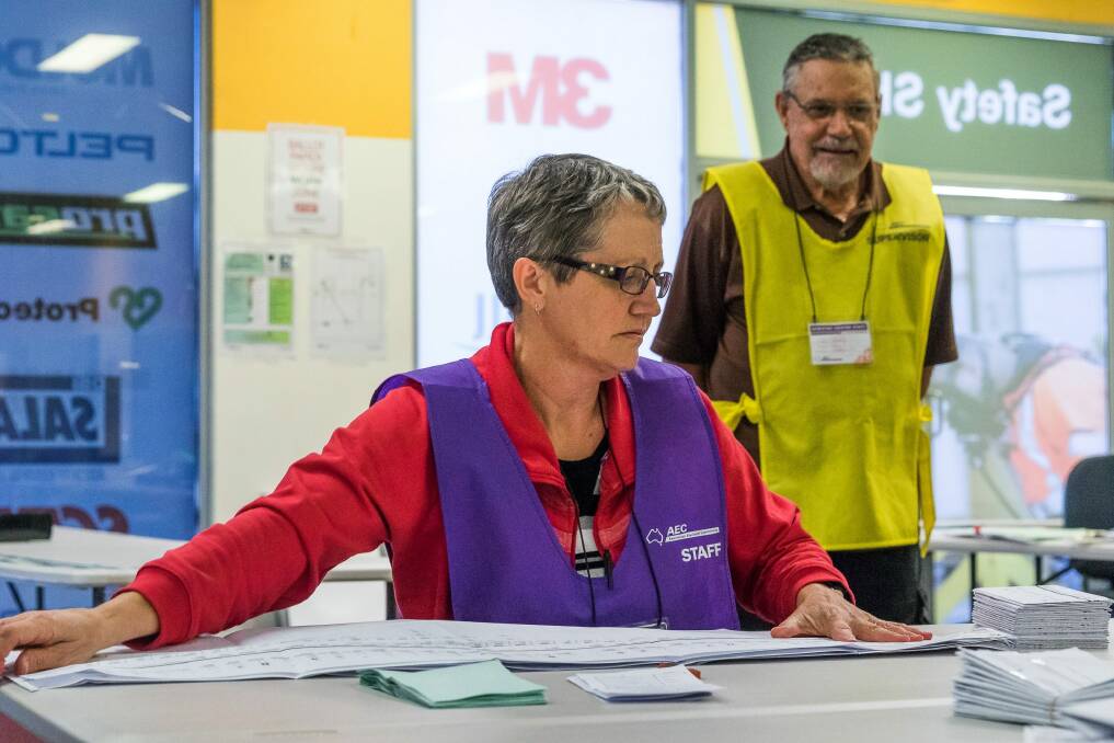 Staff and scrutineers taking part in the counting of votes in the AEC centre in Rockhampton. Photo: Steve Vit