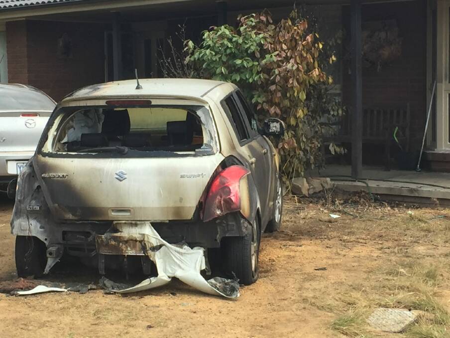 The remains of a car after it was set on fire during what police allege was a targeted attack on an Isabella Plains home. Photo: Andrew Brown