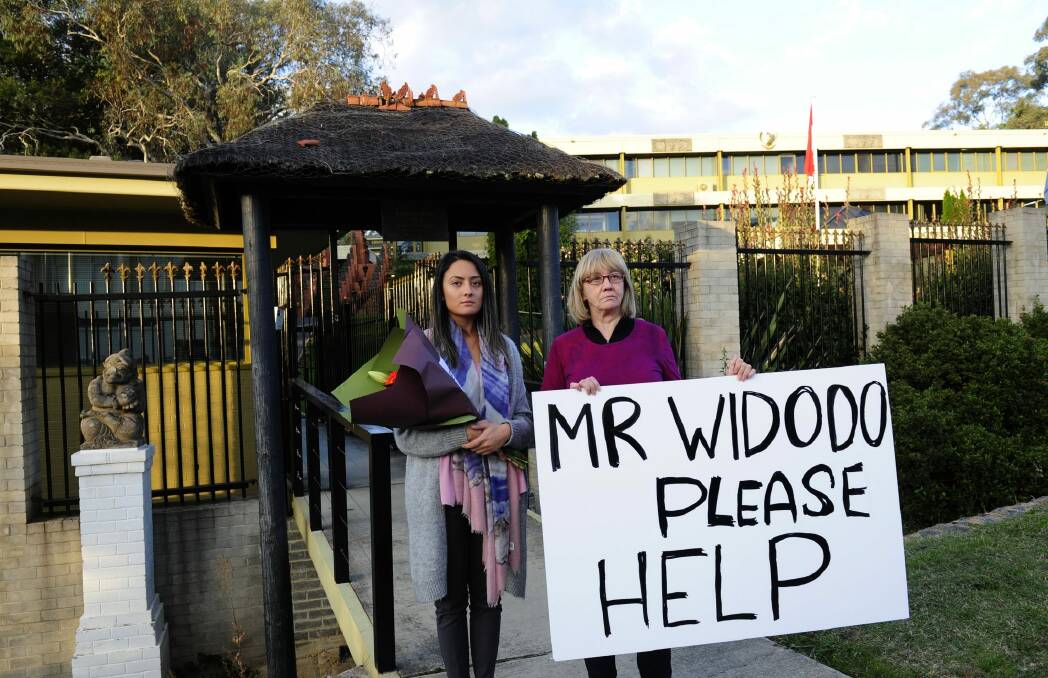 Rochelle Cooper of Downer is the co-ordinator of the candle light vigil at the Indonesian embassy for Andrew Chan and Myuran Sukumaran and Lynn Russell of Yarralumla with her sign. Photo: Melissa Adams