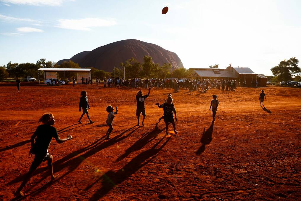 Local children play Aussies rules during the First Nations national convention at Uluru. Photo: Alex Ellinghausen