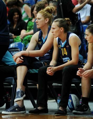 An injured Lauren Jackson and Mikaela Dombkins sit on the sidelines, as the Canberra Capitals take on Dandenong Rangers at the AIS Arena. Photo: Colleen Petch