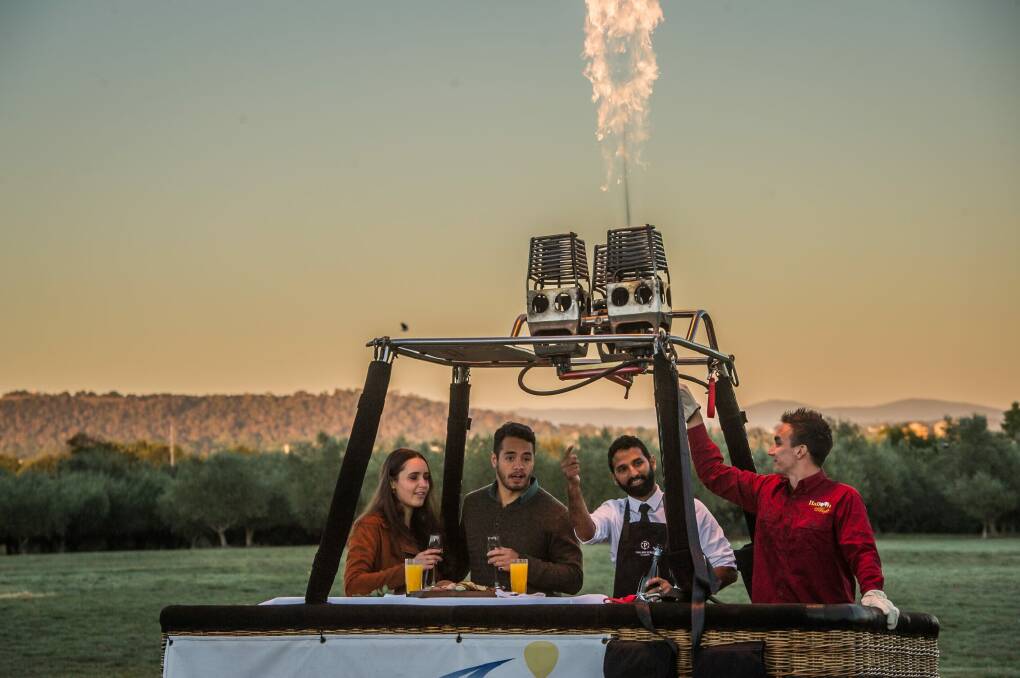 Alex Larcombe and Jonathan Stratham, try the 'Breakfast in a Balloon' experience Australia's first ever breakfast in a hot air balloon feature. With waiter Aaron Desa and pilot Jared Shore. Photo: karleen minney