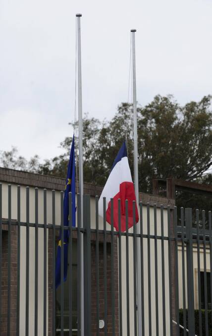 Floral tributes and flags at half mast at the Embassy of France in Yarralumla after the terrorist attacks in Paris.  Photo: Graham Tidy