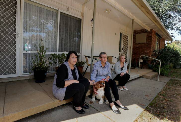 The late Joan Barrett's daughters  Sally Ayers, left, Jane Elliot and granddaughter Bec Ayers  and Joan's dog Cookie, a King Charles cavalier,  at the government house in  Lyneham  where she lived for 53 years. Photo: Richard Briggs