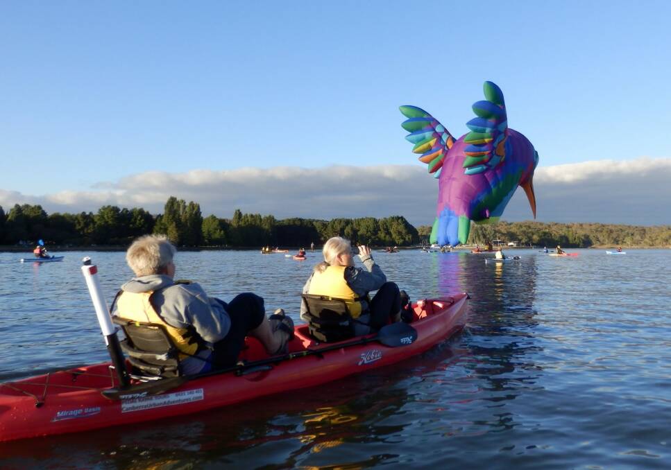 Sharon and Leeanne Chaffer in a kayak look on as the humming bird balloon skims Lake Burley Griffin. Photo: Graham Tupper