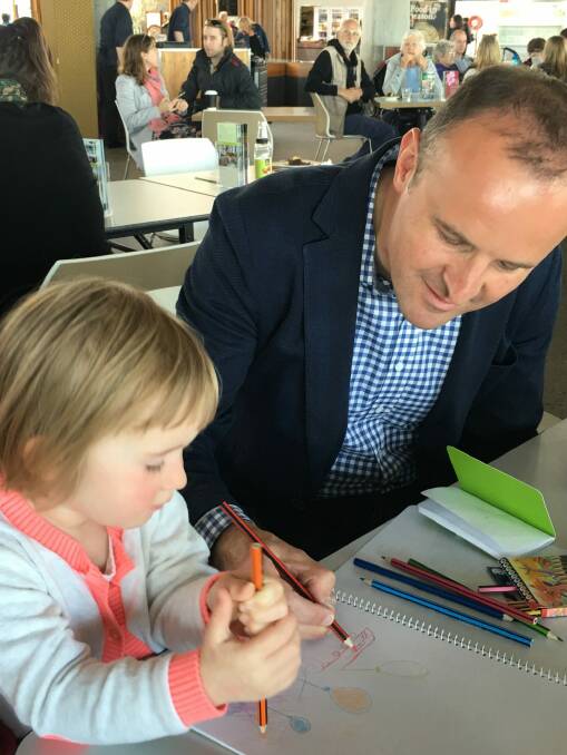 Andrew Barr shows his niece Zoe Barr, 2, how to draw a tram. Photo: Kirsten Lawson