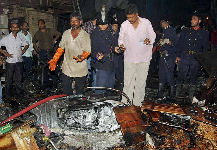 Bomb blast ... policemen inspect the site of an explosion at Zaveri Bazaar. Photo: AP