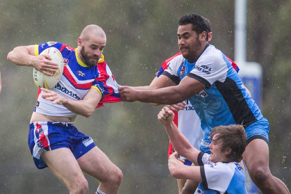 Tuggeranong Bushrangers and  Belconnen United players battle the elements at Greenway Oval. Photo: Matt Bedford
