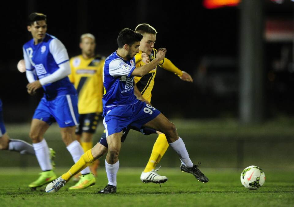 Canberra Olympic's Jordan Tsekenis and Adam Berry from the Central Coast Mariners fight for possession in last night's pre-season friendly at Gungahlin Enclosed Oval. Photo: Melissa Adams