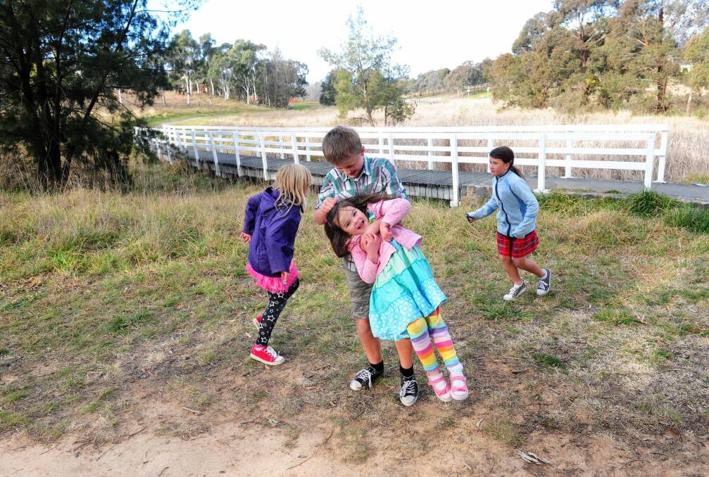 Out and about in the bush, the Beach family of Latham: Front left to right, Daniel, 12 and  Violet, 5, with Daisy, 8, and Grace, 9, playing near Ginninderra Creek. Photo: Melissa Adams