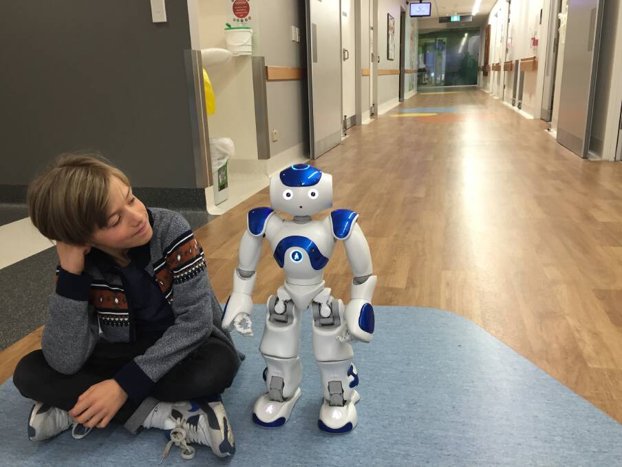 Nine-year-old Luka Milenkovic with MEDIZen, the new $25,000 robot for the Canberra Hospital which was paid for by fundraising within the local hospitality industry. Photo: Megan Doherty