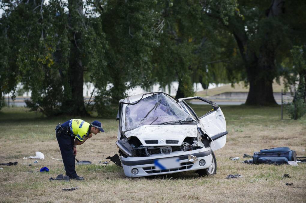 A police officer inspects the vehicle in the accident on Commonwealth Avenue. Photo: Rohan Thomson