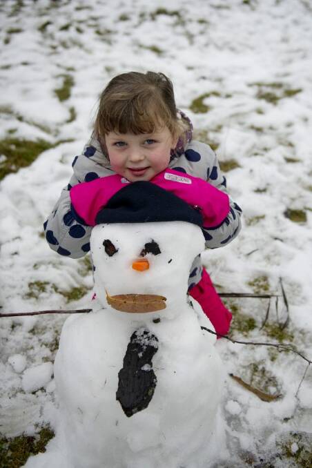 Isla Ozolin, 4, built a snowman at Corin Forest recreation park on Friday. Photo: Jay Cronan