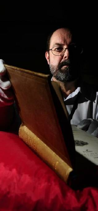  Andrew Sergeant, rare books reference librarian at the Australian National Library, with a book covered in human skin.   Photo: Stuart Walmsley