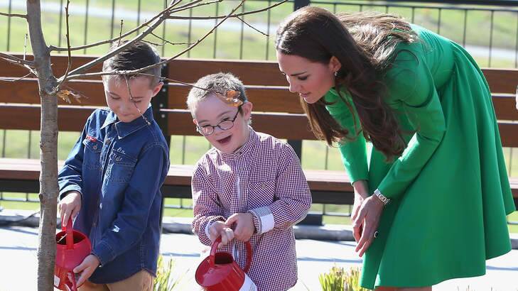 Catherine, Duchess of Cambridge watches two children help her with a tree planting. Photo: Chris Jackson
