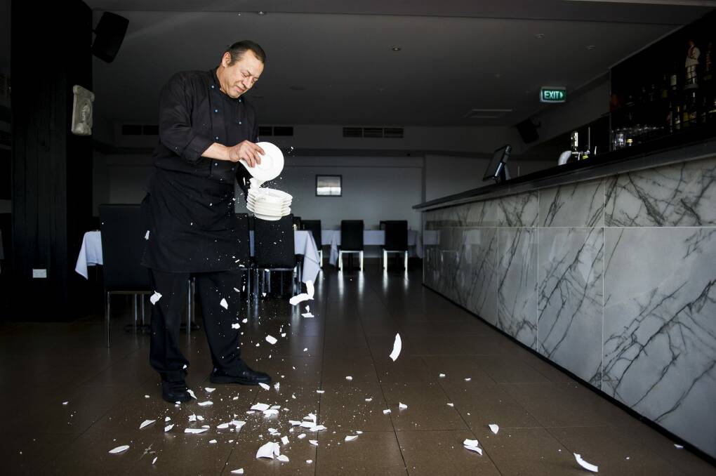 Owner of the new Plaka restaurant in Dickson, Michail Miras, smashing plates. They will be burning and smashing plates as part of Greek celebrations for the opening of the restaurant. Photo: Rohan Thomson