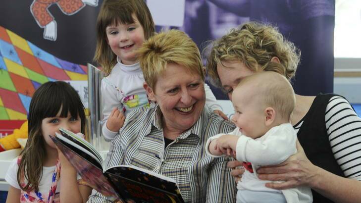 Mem, left, and Judy, read to some children. Left to right, Amelia Miller, 4, of Conder, her sister Emmerson, 2 and Judy's 7 month old nephew, Alex Horacek. Photo: Graham Tidy