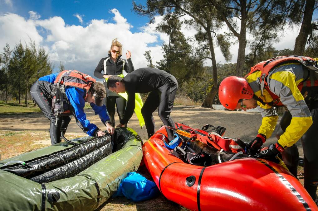 Mont Adventure Racing Team members Lee Rice, Alex Orme, Paul Cuthbert, and Tom Brazier inflate pack rafts at Casuarina Sands.   Photo: Sitthixay Ditthavong