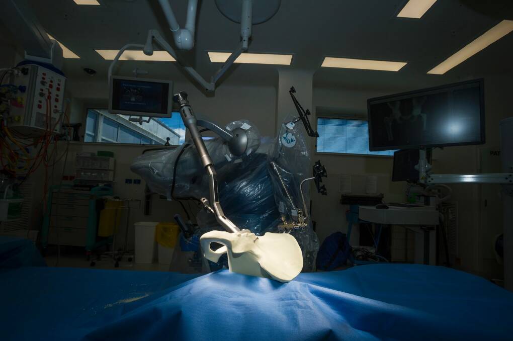 Damian Smith demonstrating how the robotic arm would function in a hip surgery. Photo: Dion Georgopoulos Photo: Dion Georgopoulos