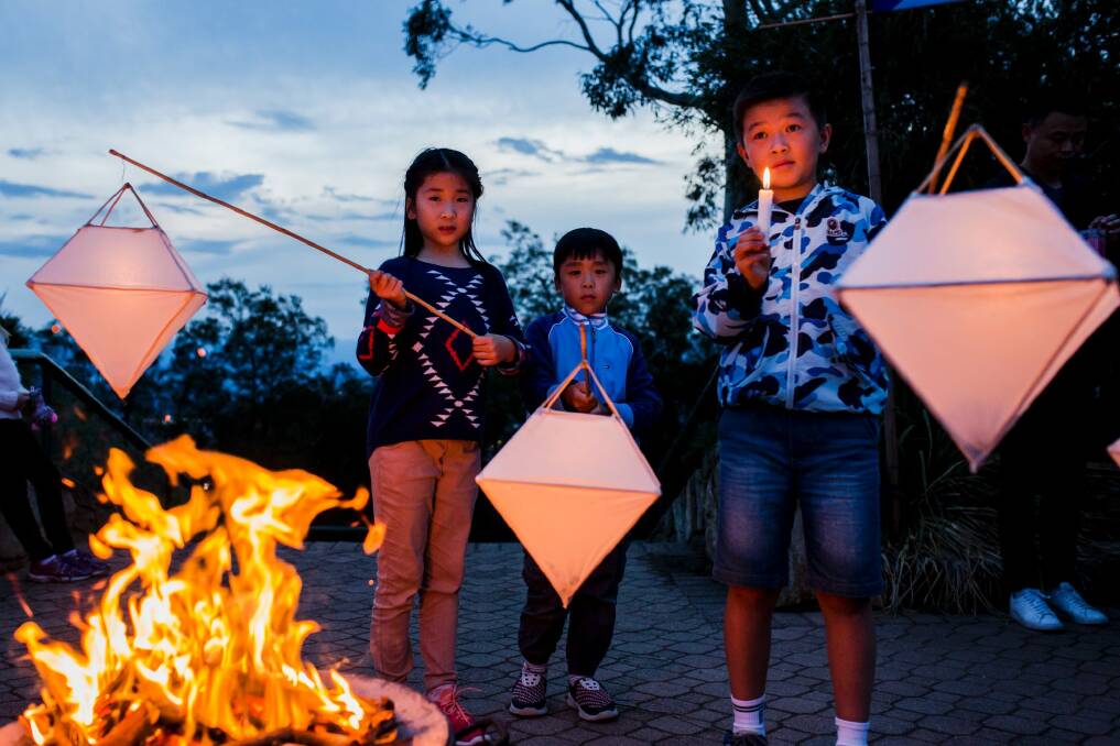 The Anzac eve peace vigil at Mount Ainslie on Monday night. From left, Angela Xu, 9, with her brother Brian, 5, and Daniel Xia, 10. Photo: Jamila Toderas