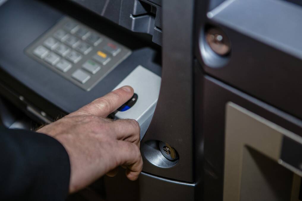 Mr Masters keys in information using the ATM. Photo by: Jamila Toderas
