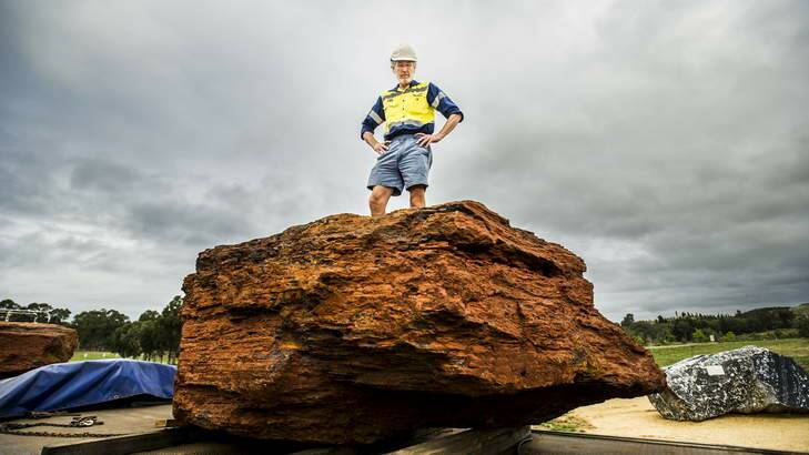 Professor Brad Pillans atop one of the new 11-tonne banded iron formation rocks at the National Rock Garden. Photo: Rohan Thomson