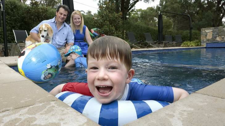 ENFORCED LEISURE: Matt Bullock with Wendy Bullock, Edmund, 2, and Oscar (foreground), 4, by the pool at their Pearce home with dog Harper. Photo: Jeffrey Chan