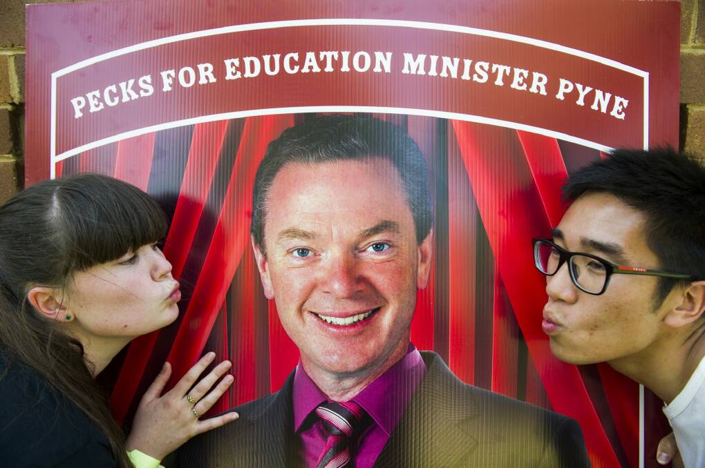 ANU politics students Caity Cameron and Nelson Tang prepare to kiss a picture of Chistopher Pyne at the ANU. Photo: Rohan Thomson