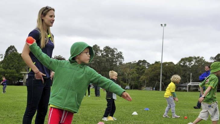Ellyse Perry gives some bowling tips to Lucas Sanden, 5, in Canberra on Saturday. Photo: Jay Cronan