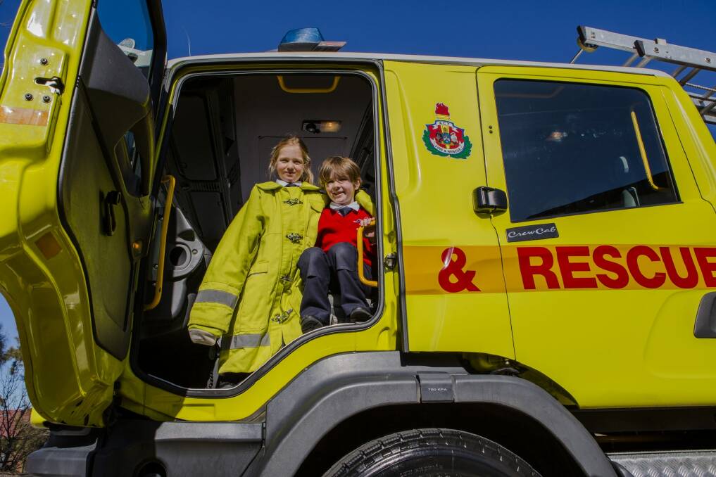 Serena Edwards and Lucas Gill, both 5, enjoy a look inside a Fire and Rescue vehicle during Monday's fire safety session at Brindabella Christian College. Photo: Jamila Toderas