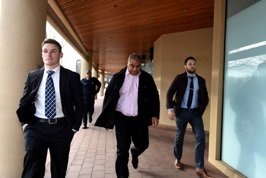 Former CFMEU official Halafihi "Fihi" Kivalu (centre) is taken into custody by plain clothed police after appearing at the Royal Commission into Trade Union Corruption hearing in Canberra. Photo: Lukas Coch