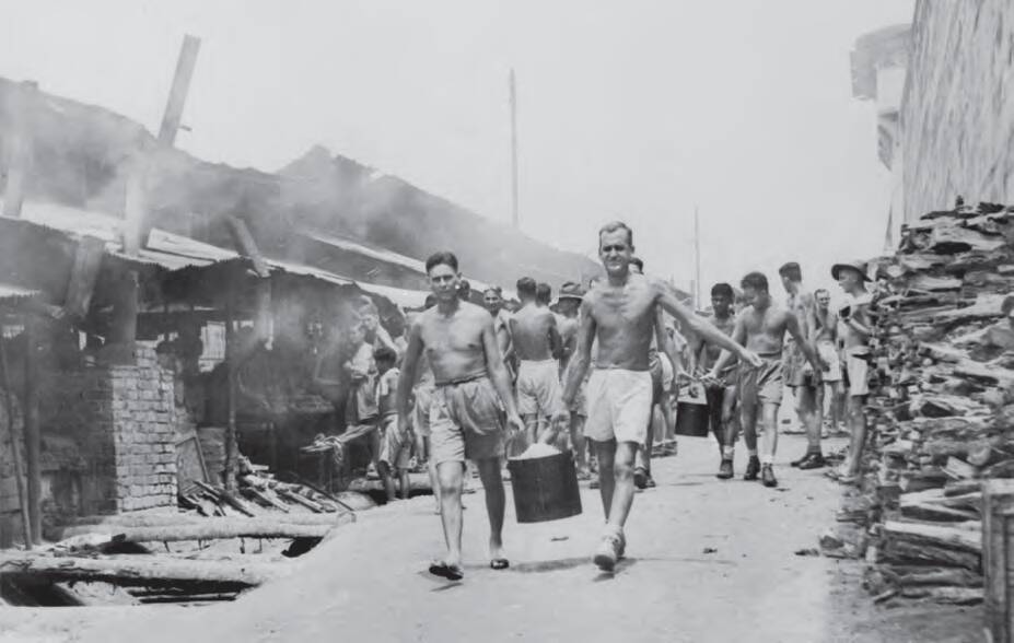 Liberated POWs at Changi carrying a bucket of rice from the mess. The inquiry is investigating recognition for prisoners killed while escaping Japanese camps. Photo: Australian War Memorial. AWM 019192.