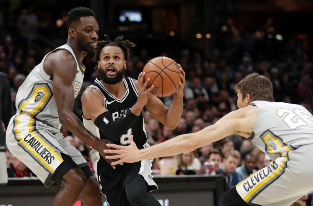 San Antonio Spurs' Patty Mills, center, from Australia, drives between Cleveland Cavaliers' Jeff Green, left, and Kyle Korver in the first half of an NBA basketball game, Sunday, Feb. 25, 2018, in Cleveland. (AP Photo/Tony Dejak) Photo: TONY DEJAK