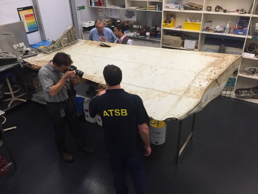 Malaysian and Australian investigators examine the piece of aircraft debris found on Pemba Island off the coast of Tanzania Photo: ATSB