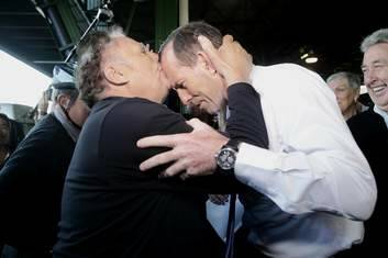 Nino Barbaro kneels before Tony Abbott before rising to kiss his forehead, during a visit to the Sydney Markets.