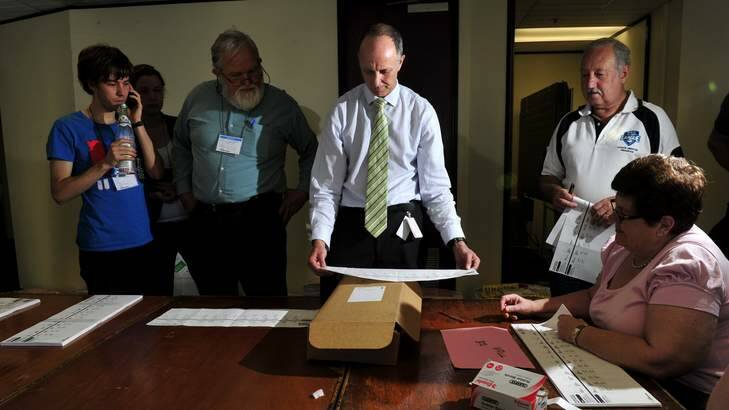 Australian electoral officer for the ACT Ian Gordon is watched by scrutineer Joel Dignam, 22, of Cook, Dierk von Behrens and counting supervisor Brian Lindsay. Photo: Melissa Adams