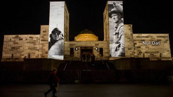 Pictures of service personnel and battles projected onto the war memorial on Anzac Day. Photo: Rohan Thomson