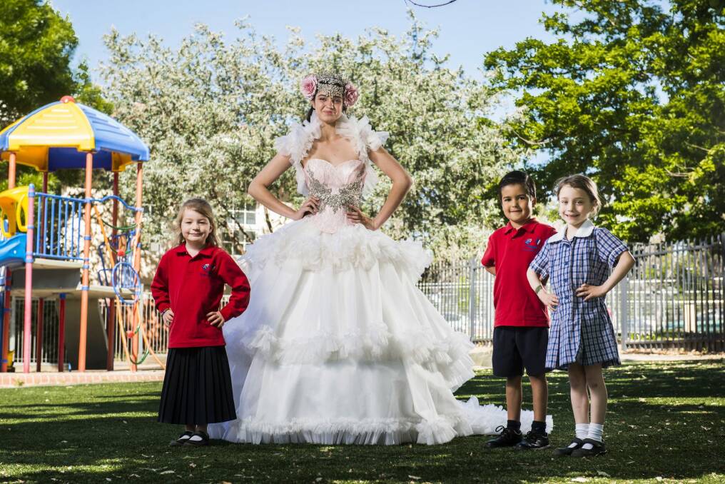 Model Ilana Davies wearing a Rockstars and Royalty dress with Telopea Park kindergarten students, Diego Castro, Sophia Baker (blue dress), and Sarah Kay (wearing red), ahead of the school fate which includes a fashion parade.  Photo: Rohan Thomson